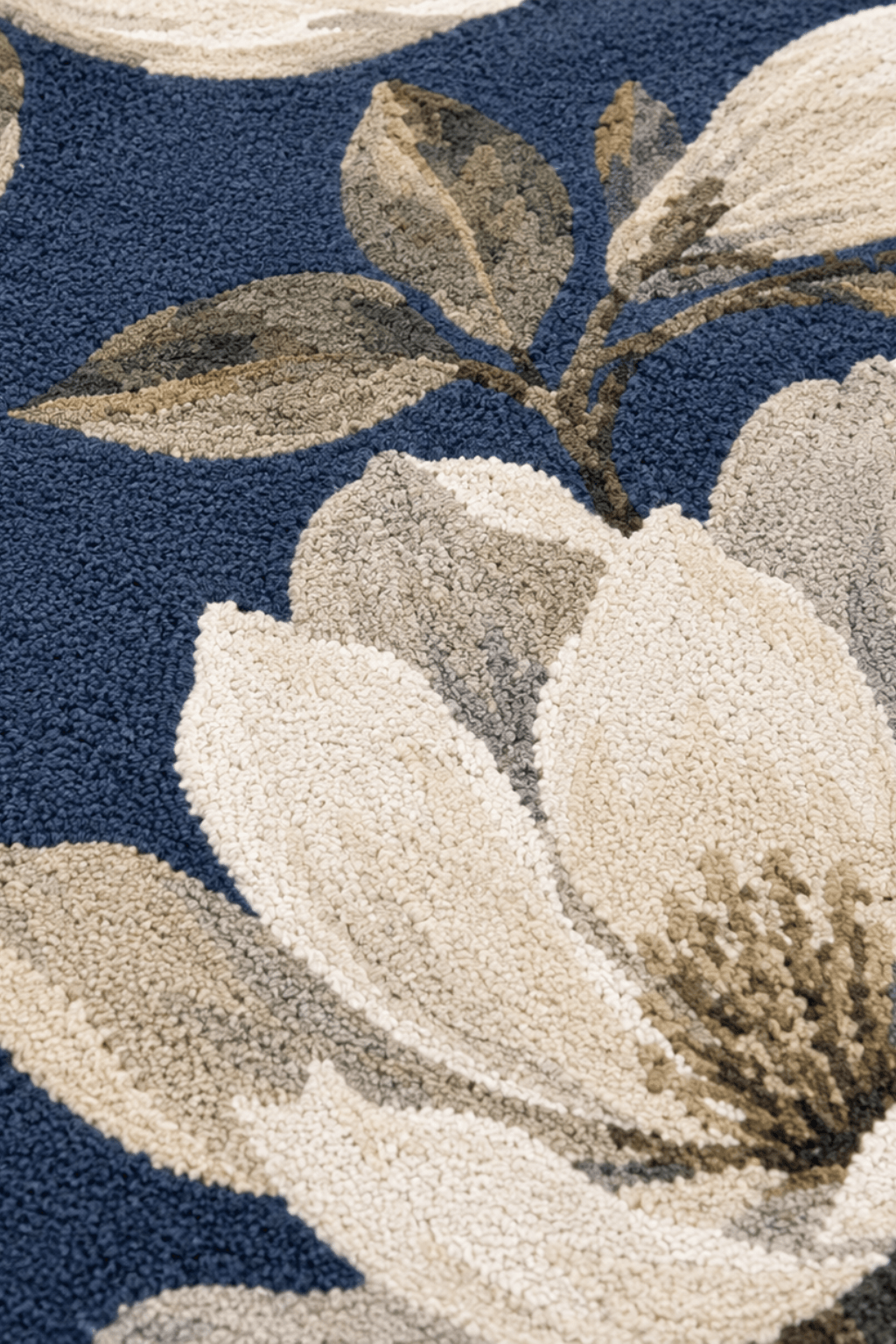 Detail of magnolia bloom hand-tufted rug featuring oversized floral patterns on a navy background.
