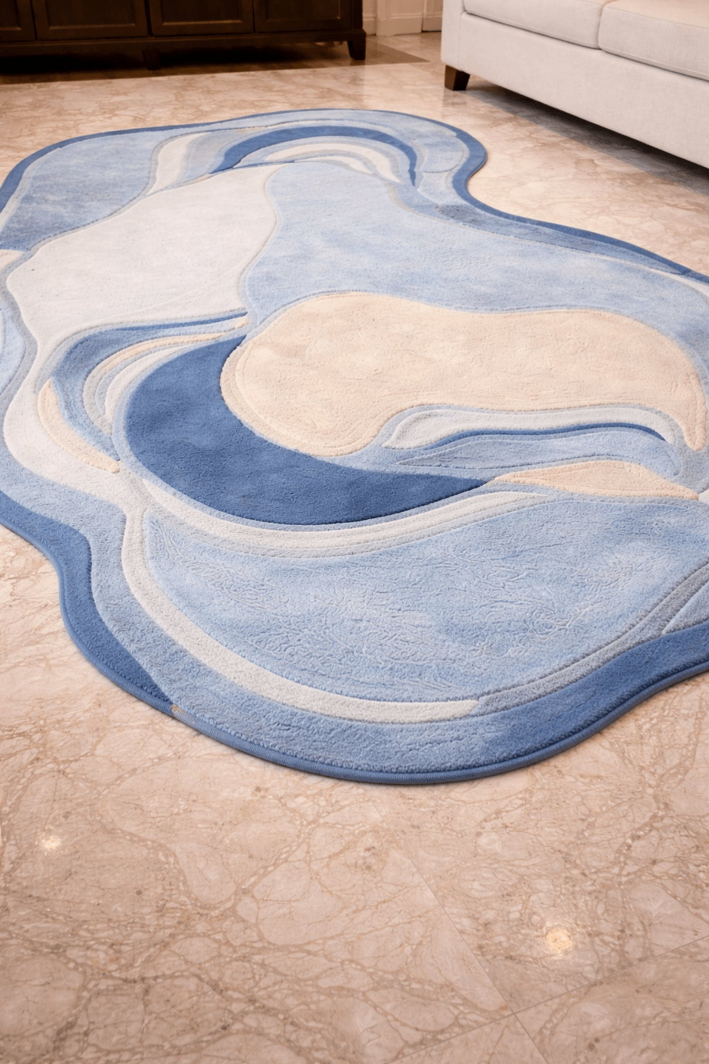 Azure agate contour rug featuring soft blue and ivory tones on a marble floor.