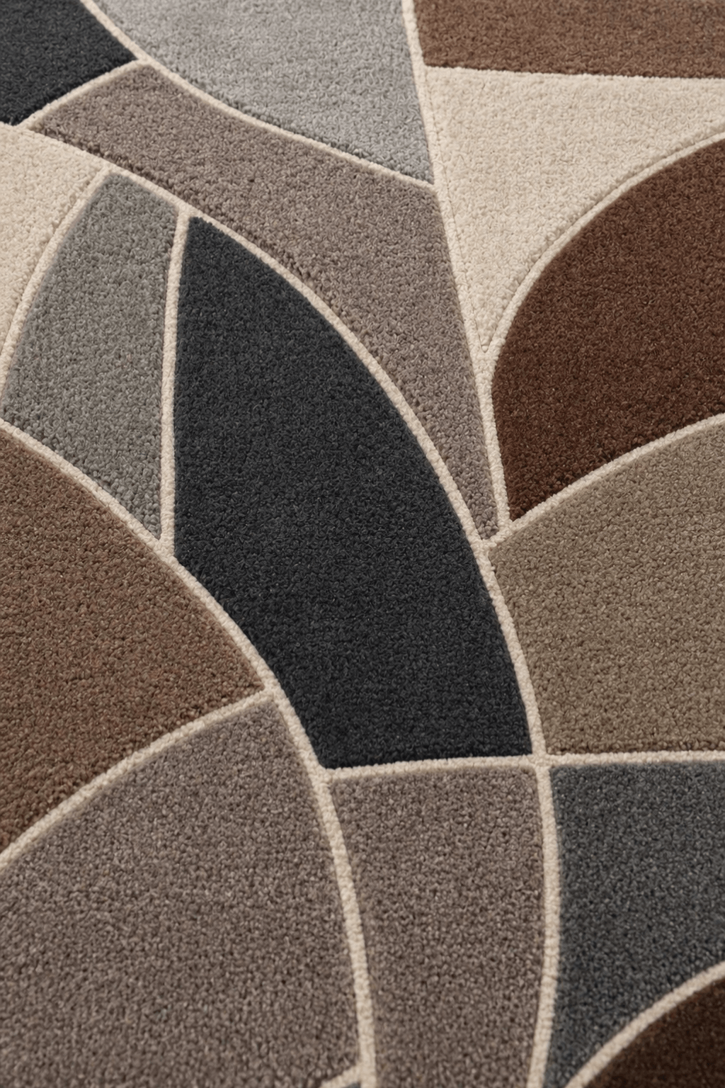 Geometric hand tufted rug featuring bold curves and earthy tones of mocha, taupe, charcoal, and beige.