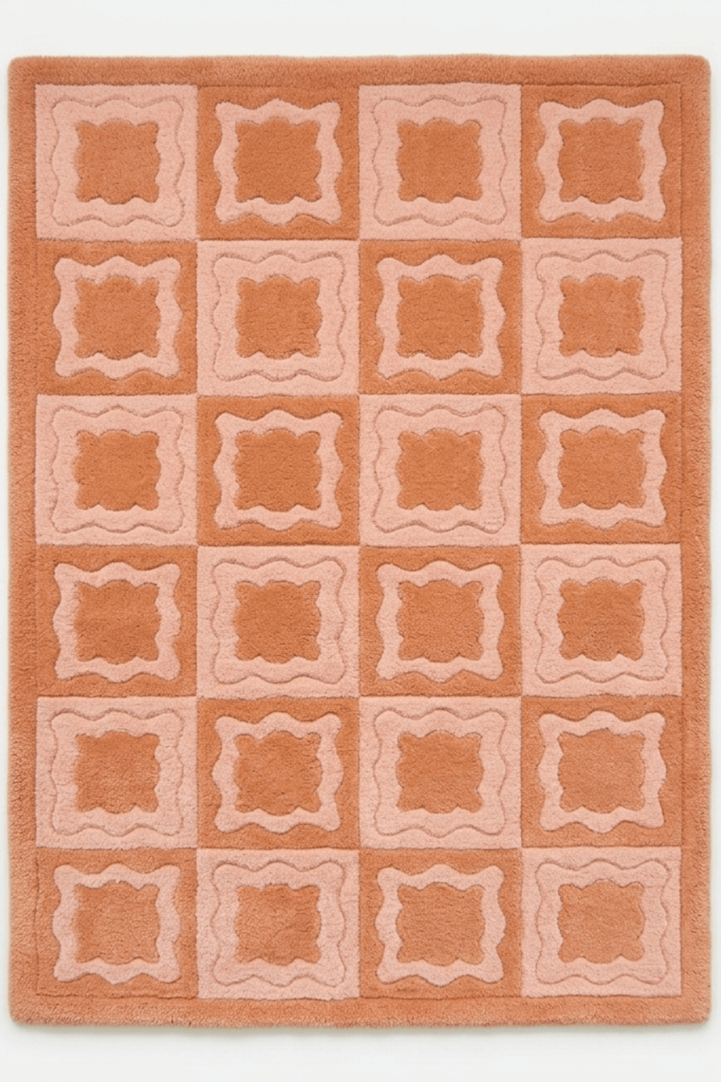 Peach mosaic luxe rug featuring a rhythmic grid of soft scalloped motifs in peach and blush tones.