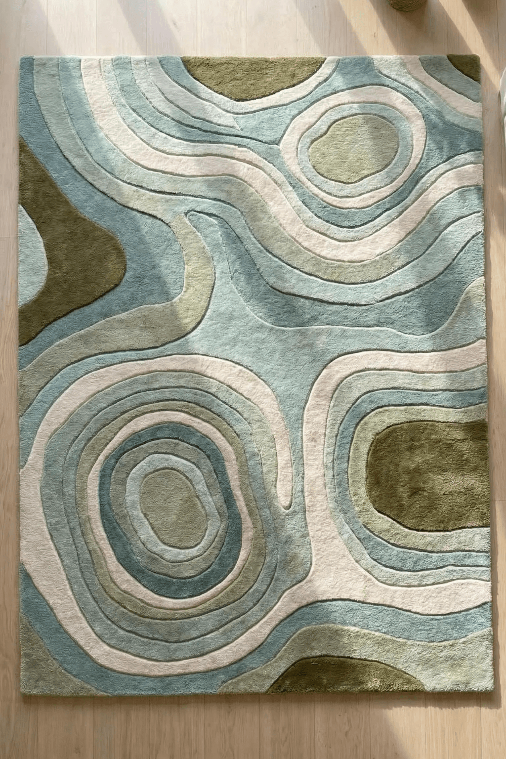 Nature-inspired contour rug in soft sage, olive, and ivory tones with fluid, organic shapes.