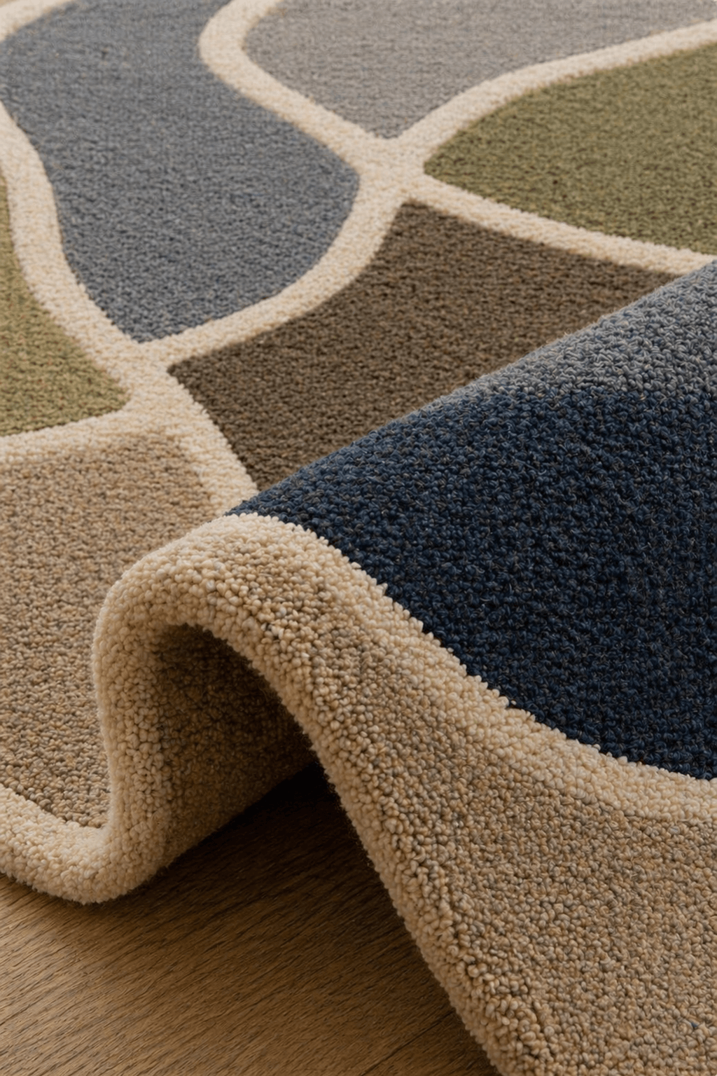 Organic geometry hand tufted rug showcasing soft curves and rich colors like navy, olive green, and beige.