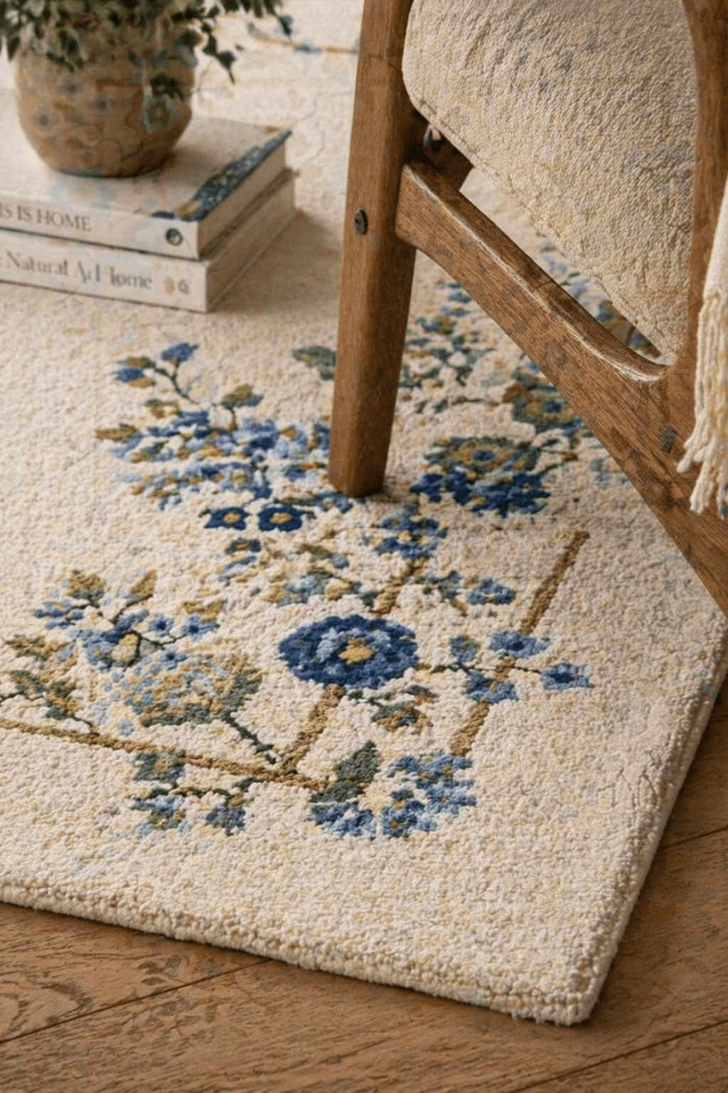 Floral border wool rug showcasing intricate blue floral designs on a soft ivory background, perfect for elegant decor.