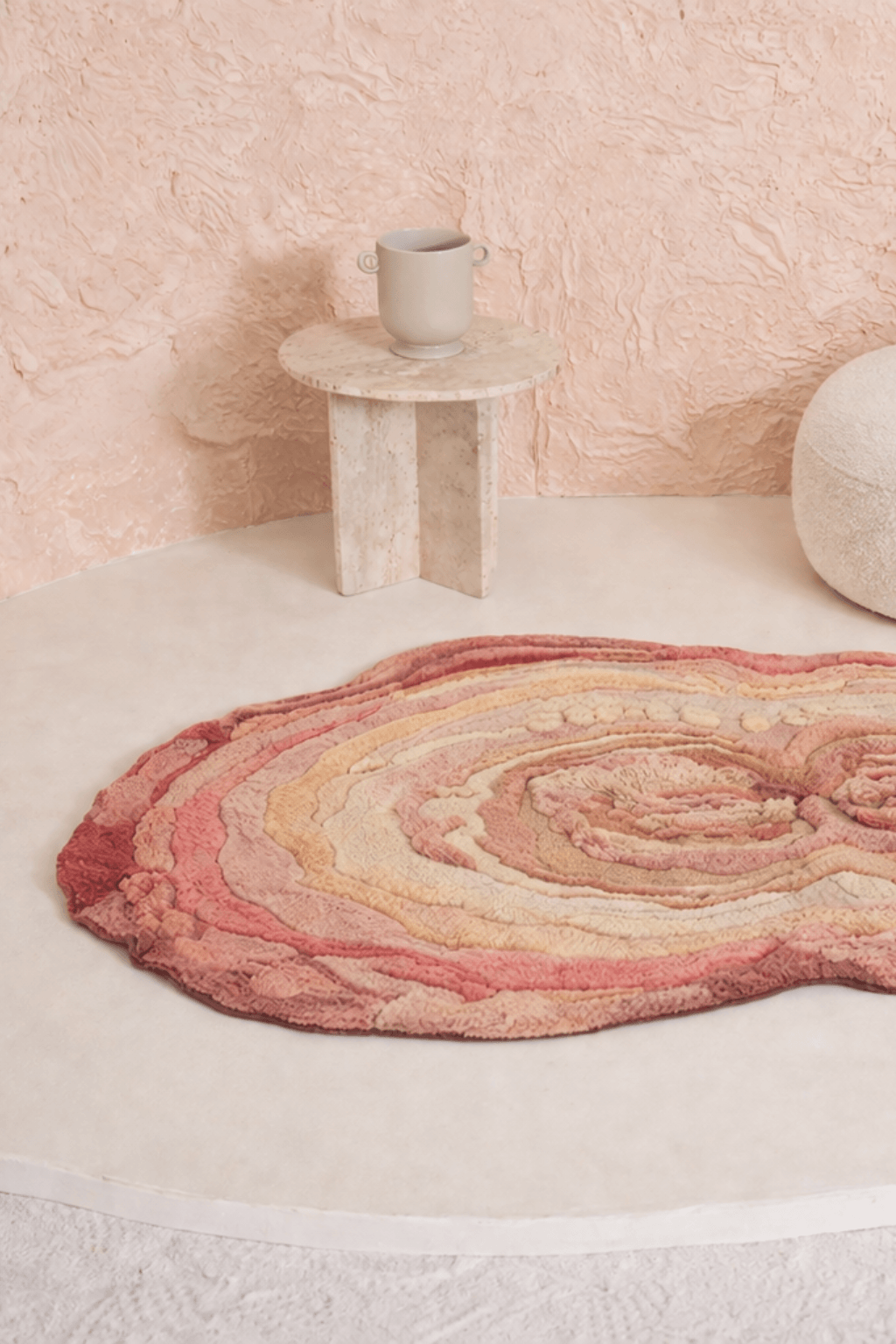 Blush Terrain Organic Rug with layered contours in soothing blush and coral shades on a light surface.