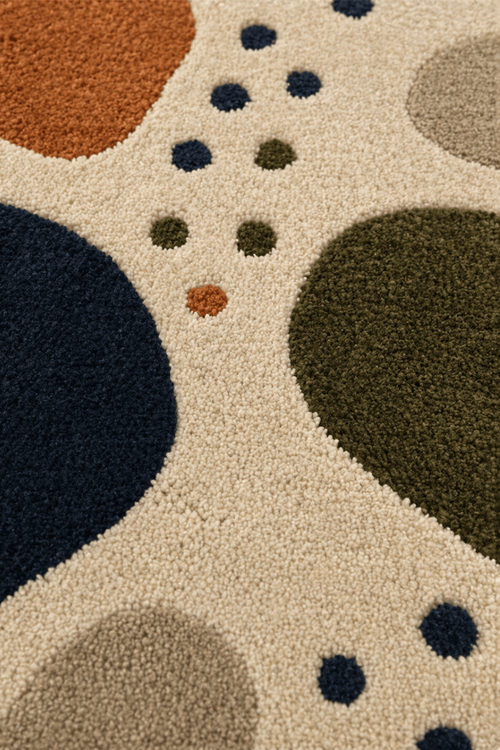 Organic pebble abstract rug featuring irregular shapes in navy, olive green, rust, and beige.