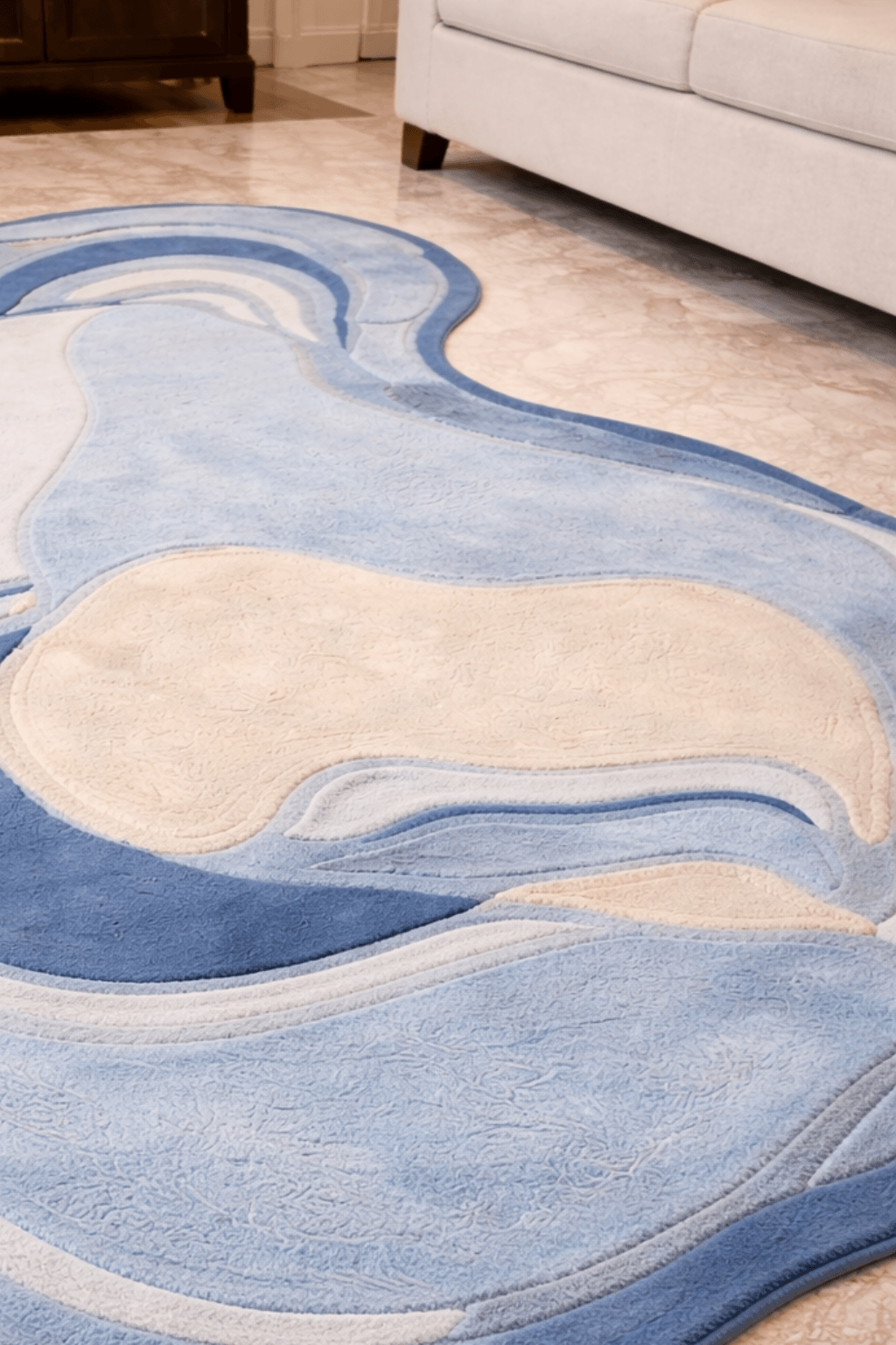 azure agate contour rug with soft curves in dusty blue and ivory tones on living room floor