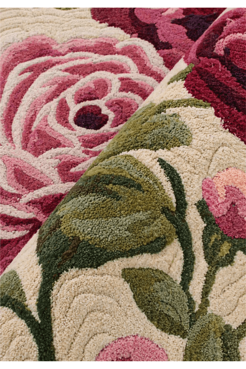 Close-up of a vintage floral garden rug featuring lush rose and leaf designs in rich colors.