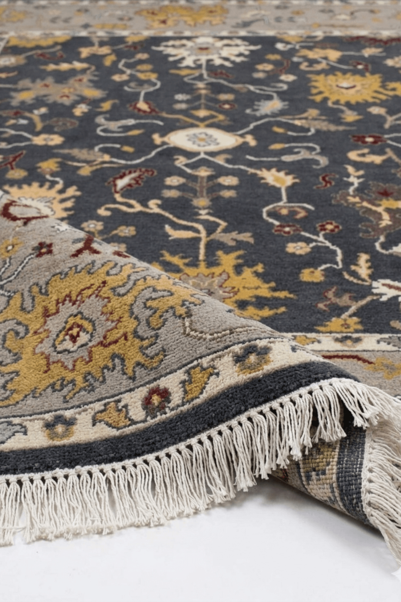Heritage hand-knotted oushak rug showcasing intricate charcoal and ochre patterns with fringe detailing.