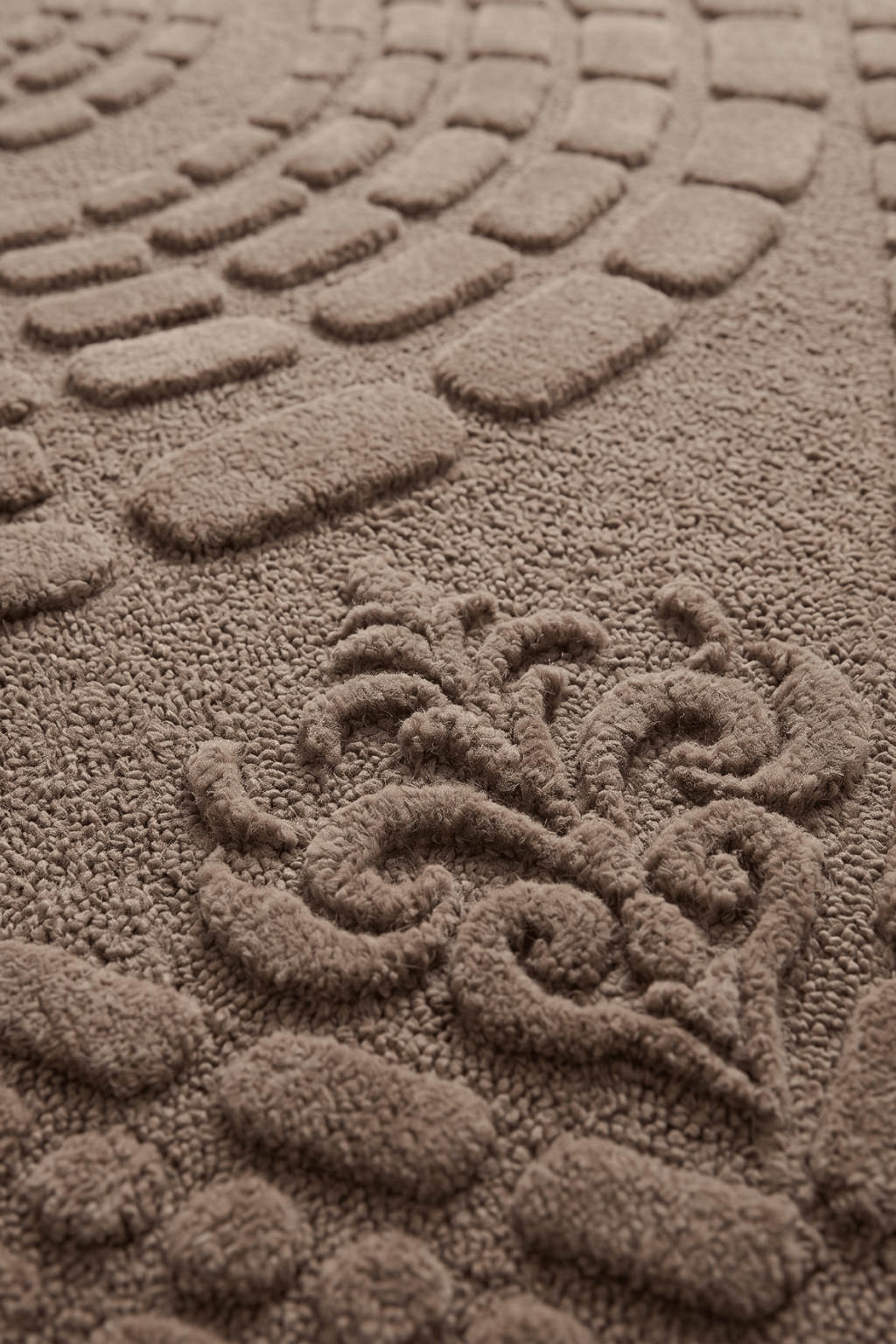 Close-up of the Concentric Earth Sculpted Rug showcasing its rich mocha-taupe tones and intricate texture.