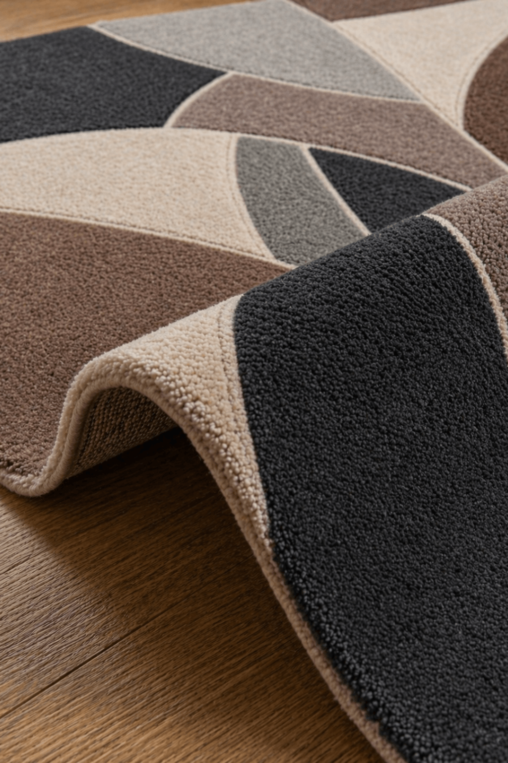 geometric hand tufted rug displaying bold curved lines in earthy tones of mocha, taupe, charcoal, and soft beige
