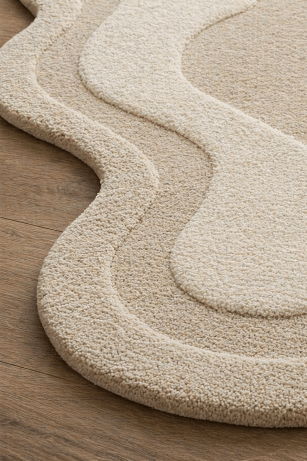 Desert Contour Luxe Rug showcasing soothing neutral tones and abstract freeform silhouette on wooden floor.