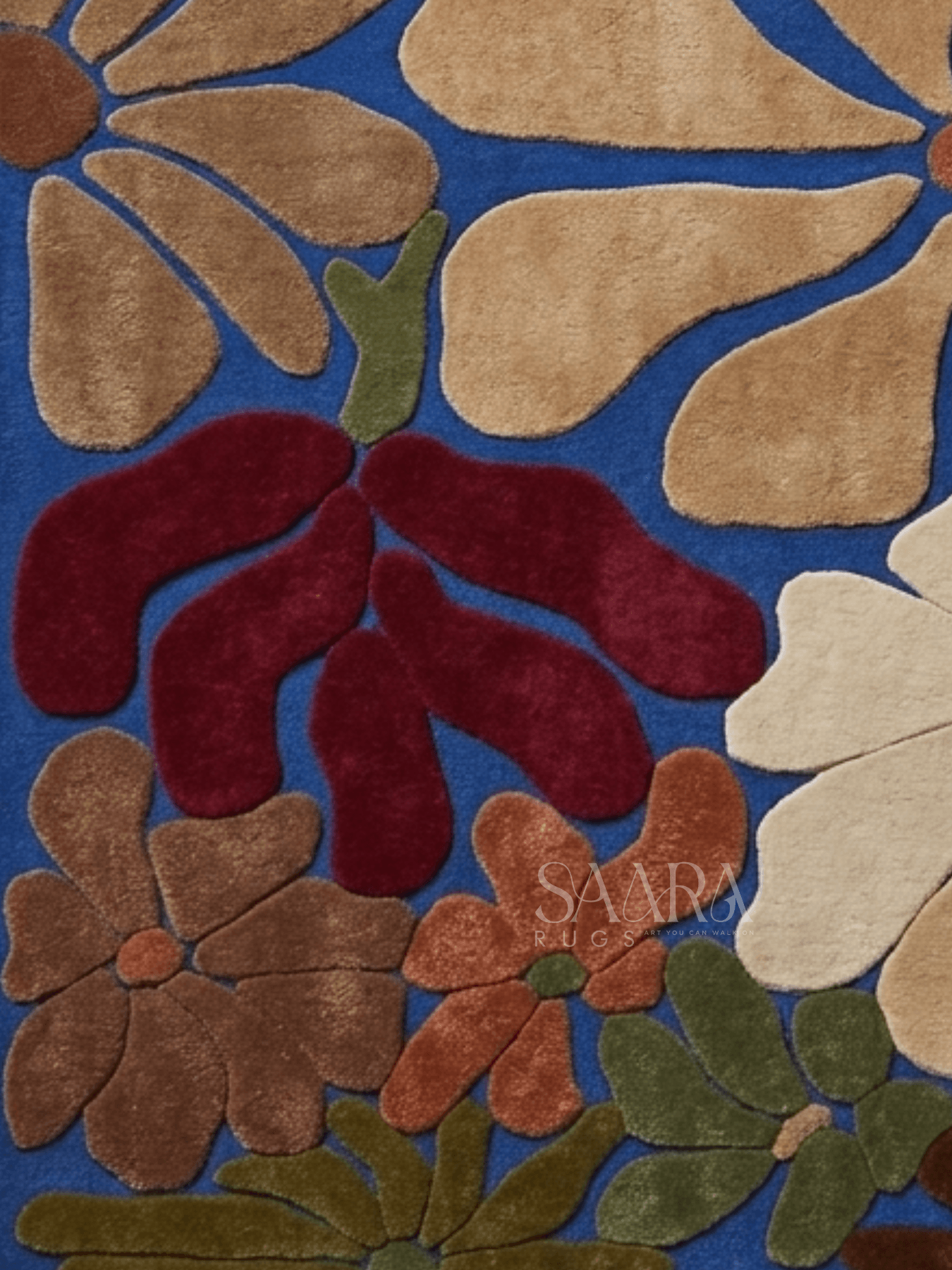Modern floral wool rug with a bold blue base and oversized floral motifs in warm earthy tones.