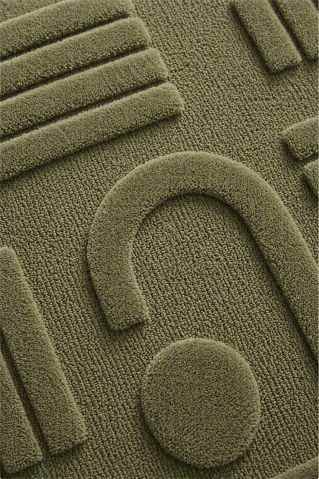 Close-up of the moss geo-sculpt rug showing intricate high-low pile design in earthy moss green.