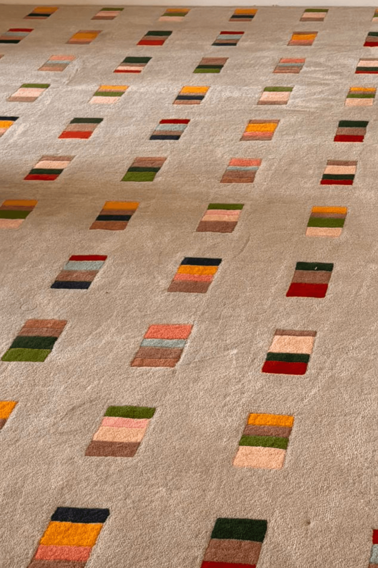 Mosaic Rhythm Rug, a geometric pattern area rug with multicolor block motifs on a soft neutral base.