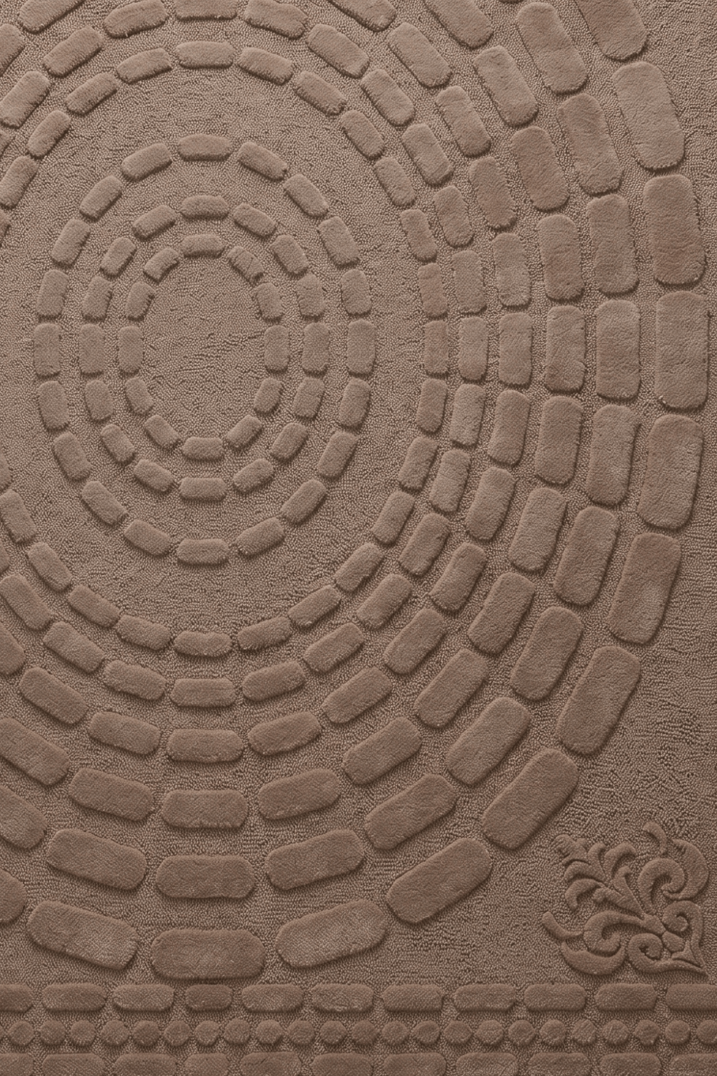 concentric earth sculpted rug featuring a textured circular pattern in rich mocha-taupe tones.