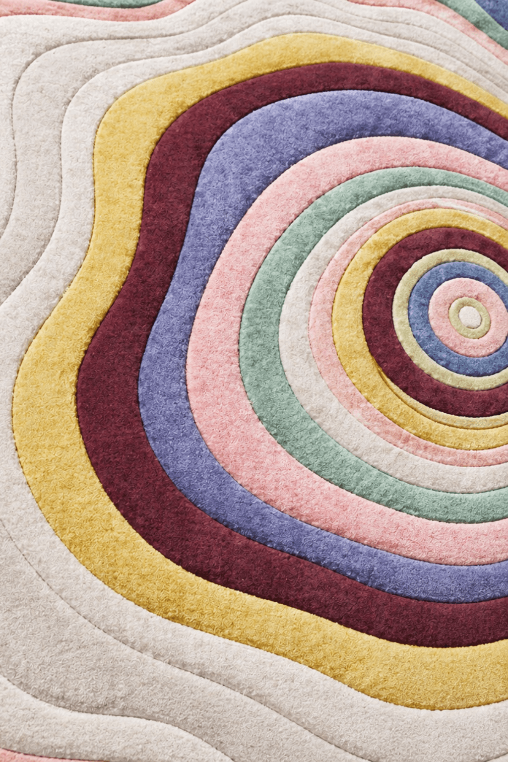 Celestial ripple rug featuring concentric flowing bands in soft pastels and vibrant colors.