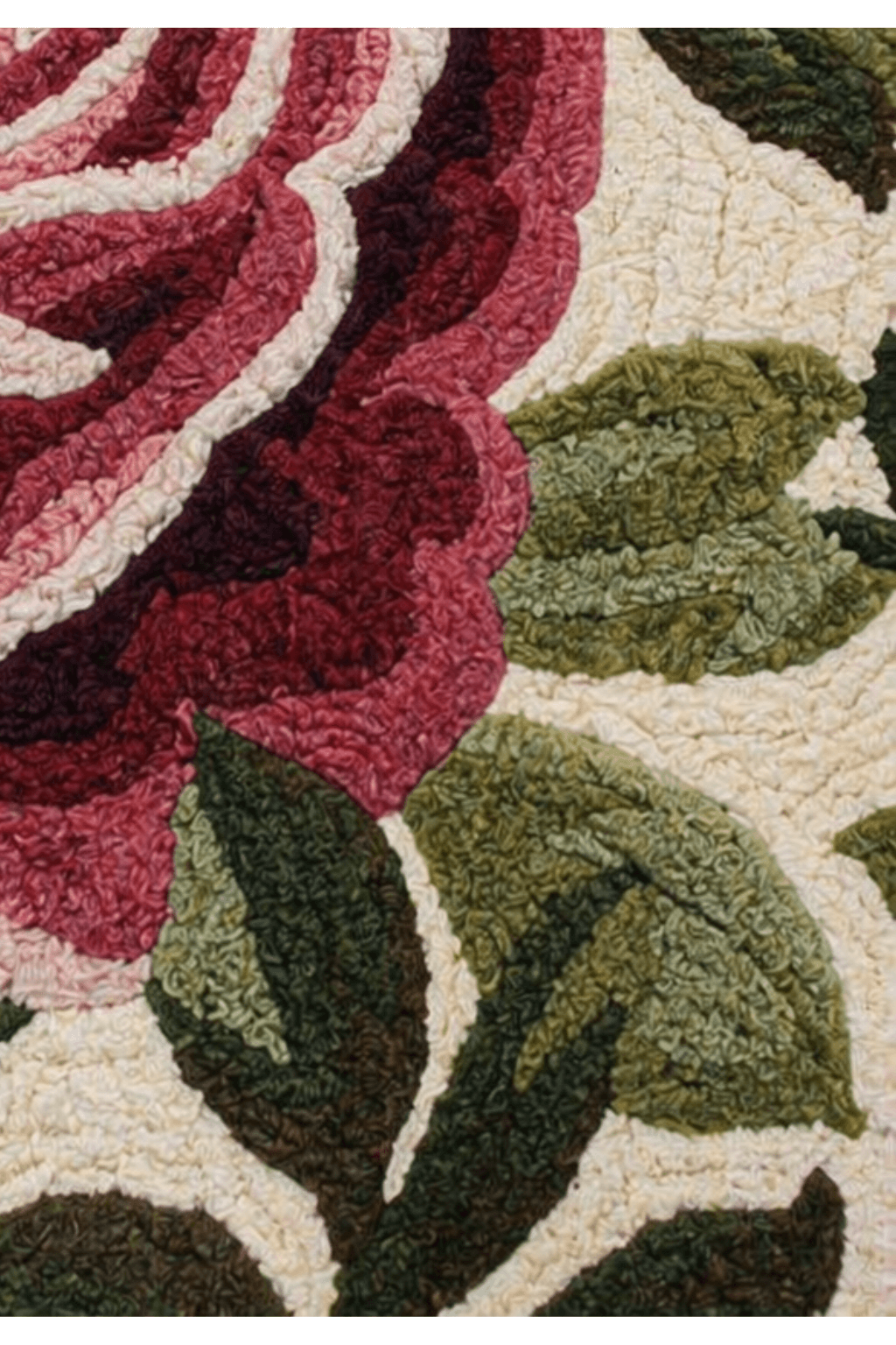Close-up of vintage floral garden rug showcasing rich burgundy roses and layered green leaves.