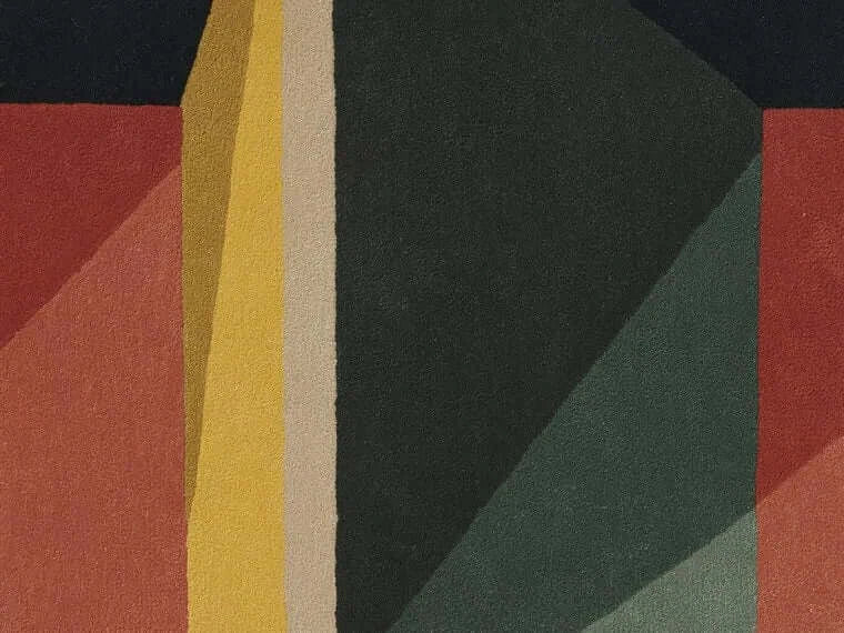 Close-up of the Facet Mirage Hand-Tufted Rug showcasing bold geometric colors and plush New Zealand wool texture.