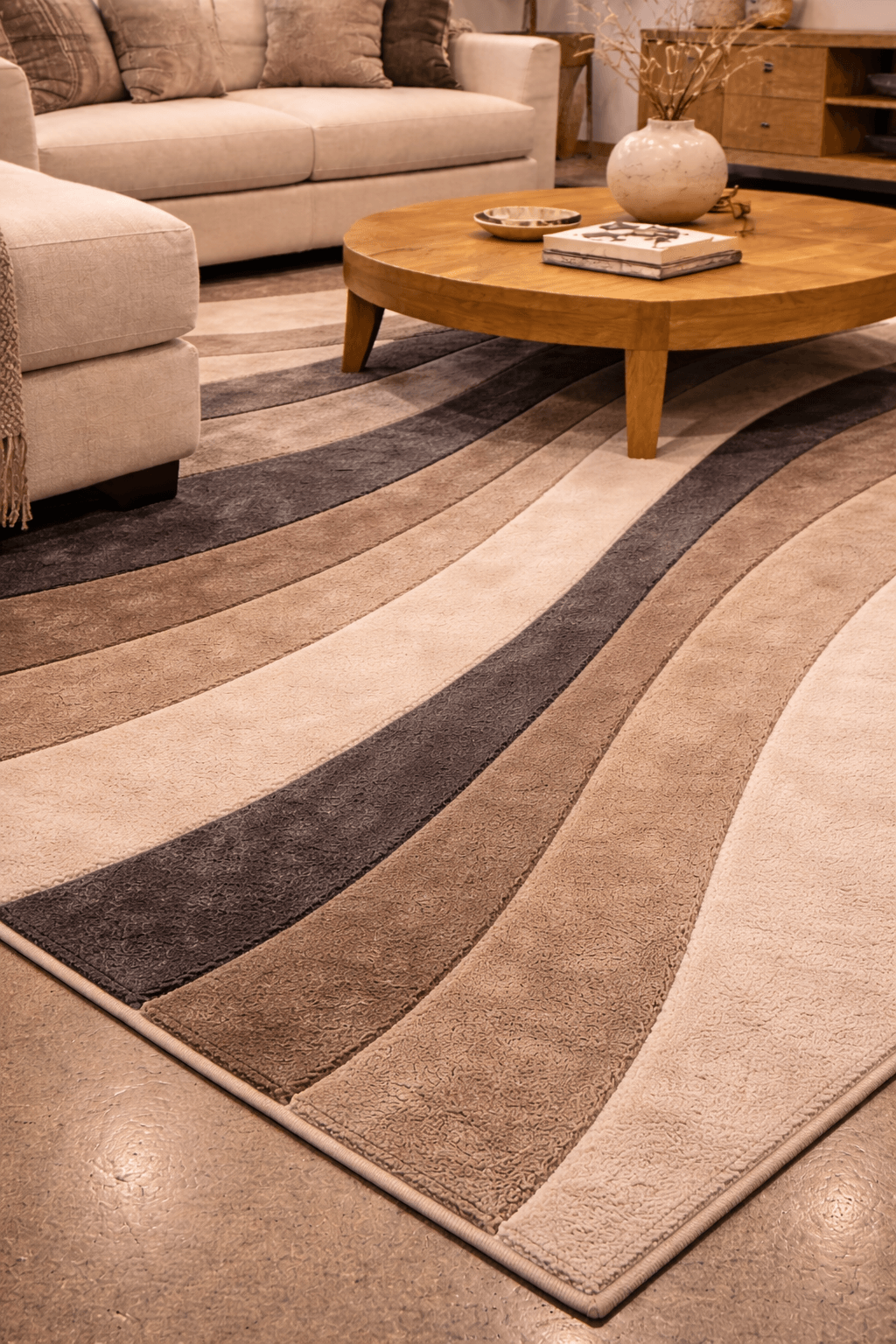 Contemporary wave rug with undulating patterns in creams and charcoals, enhancing modern living room decor.