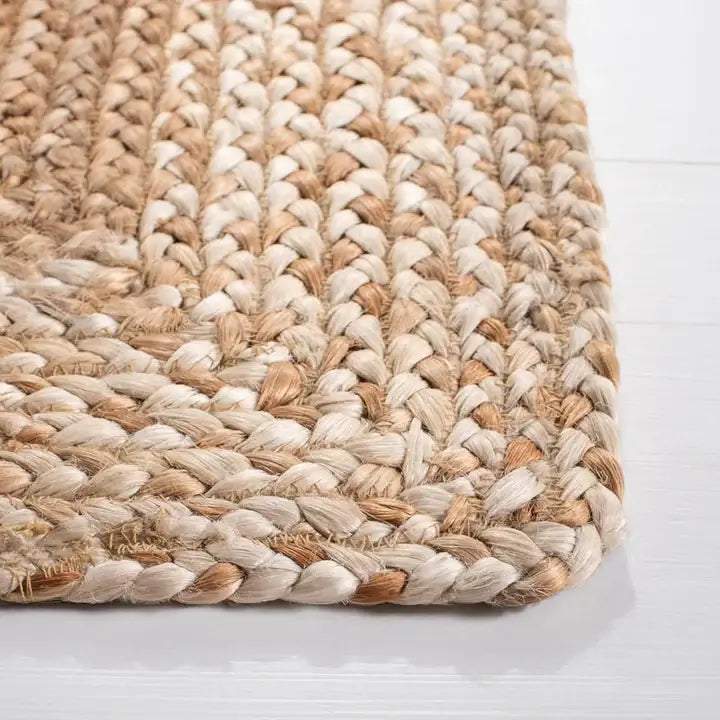 Close-up of the Ivory Fade Braided Jute Rug showcasing its intricate braided design and natural tone variations.