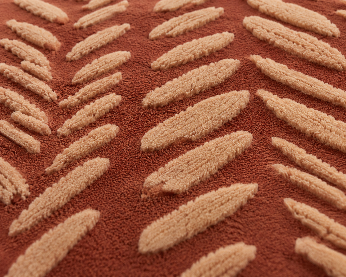 Close-up of the Savannah Trail Rug featuring hand-tufted floral area rug motifs in rich terracotta and textured ivory.