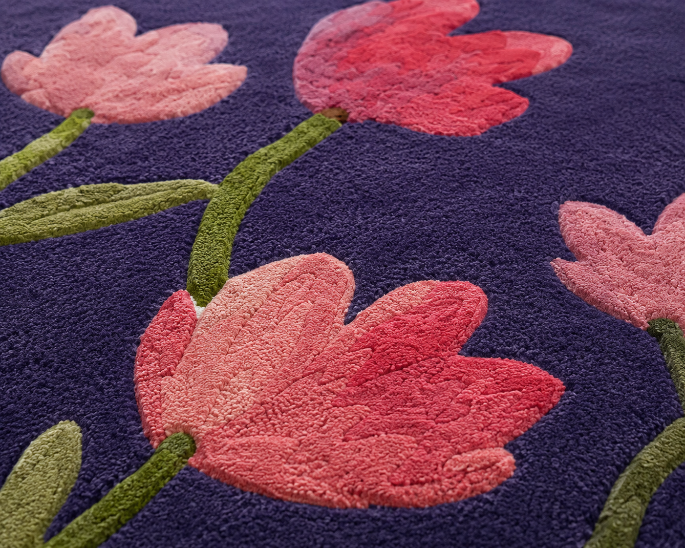 Close-up of the violet blossom floral rug featuring pink and raspberry blooms on a violet background.