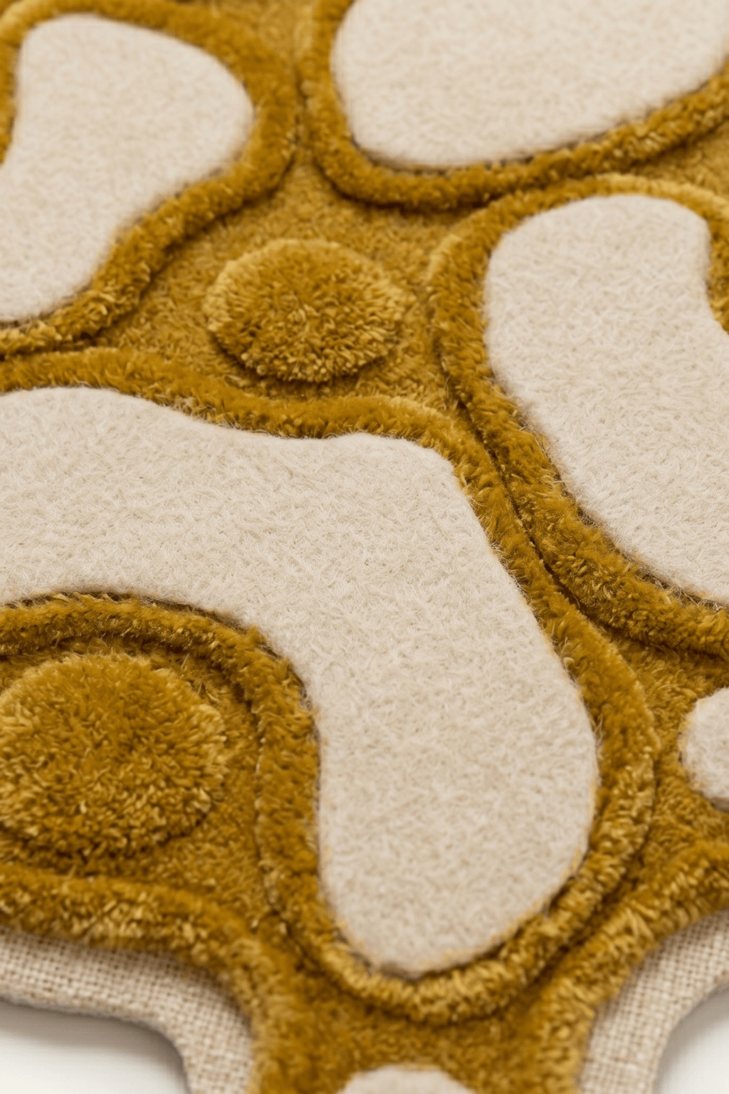 Close-up of artistic multi-texture rug, Amorphous Ochre, showcasing its unique multi-pile height and contrasting colors.