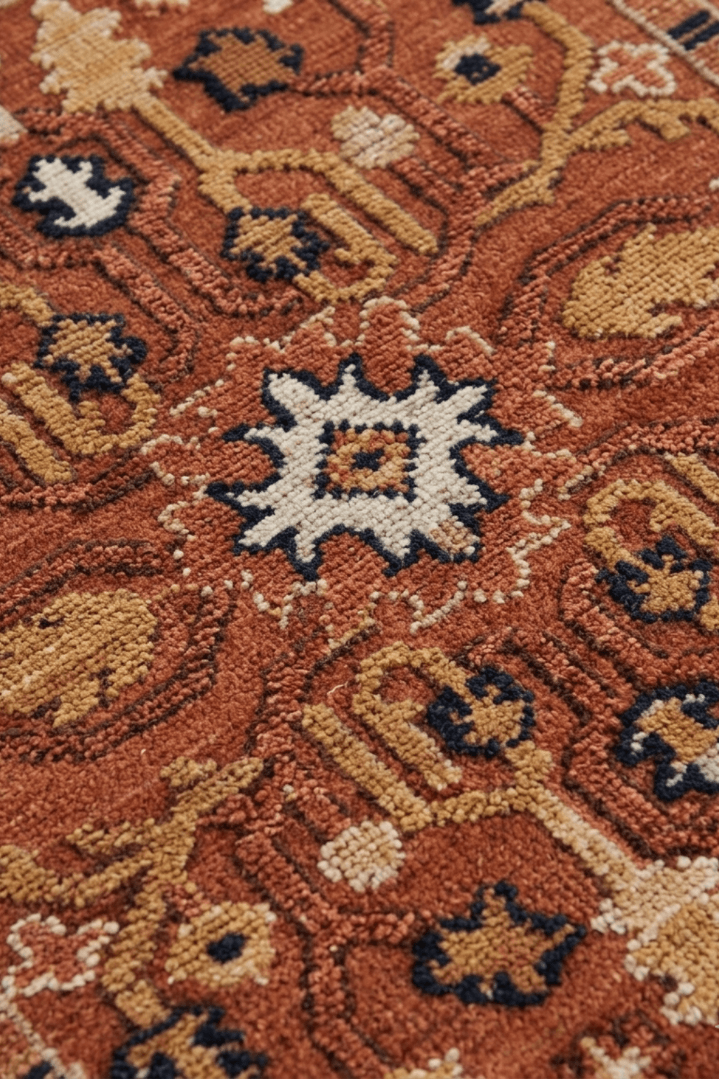Close-up of a tribal geometric area rug featuring intricate designs in rich terracotta and burnt orange tones.