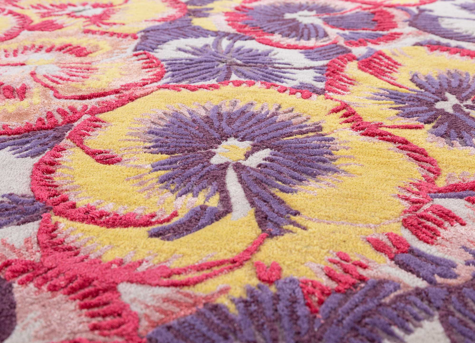 Hand tufted candy pink rug with floral designs in purple and yellow, adding elegance to your living space.