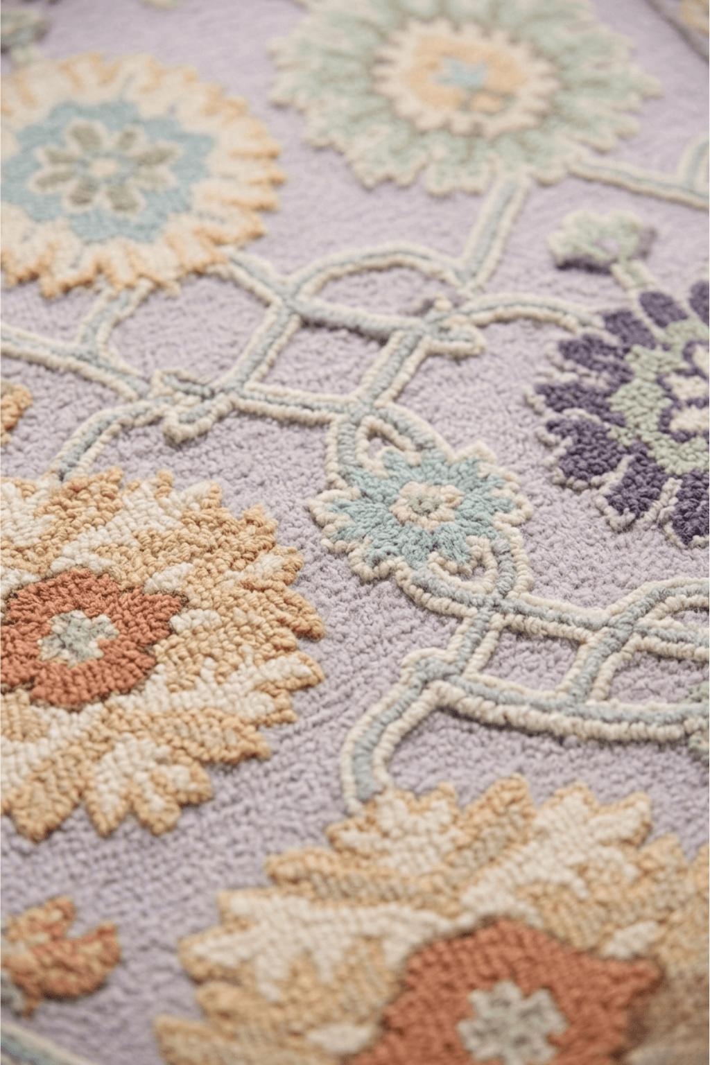 Close-up of the Seraphina hand-knotted wool rug featuring oversized botanical medallions in soft colors.