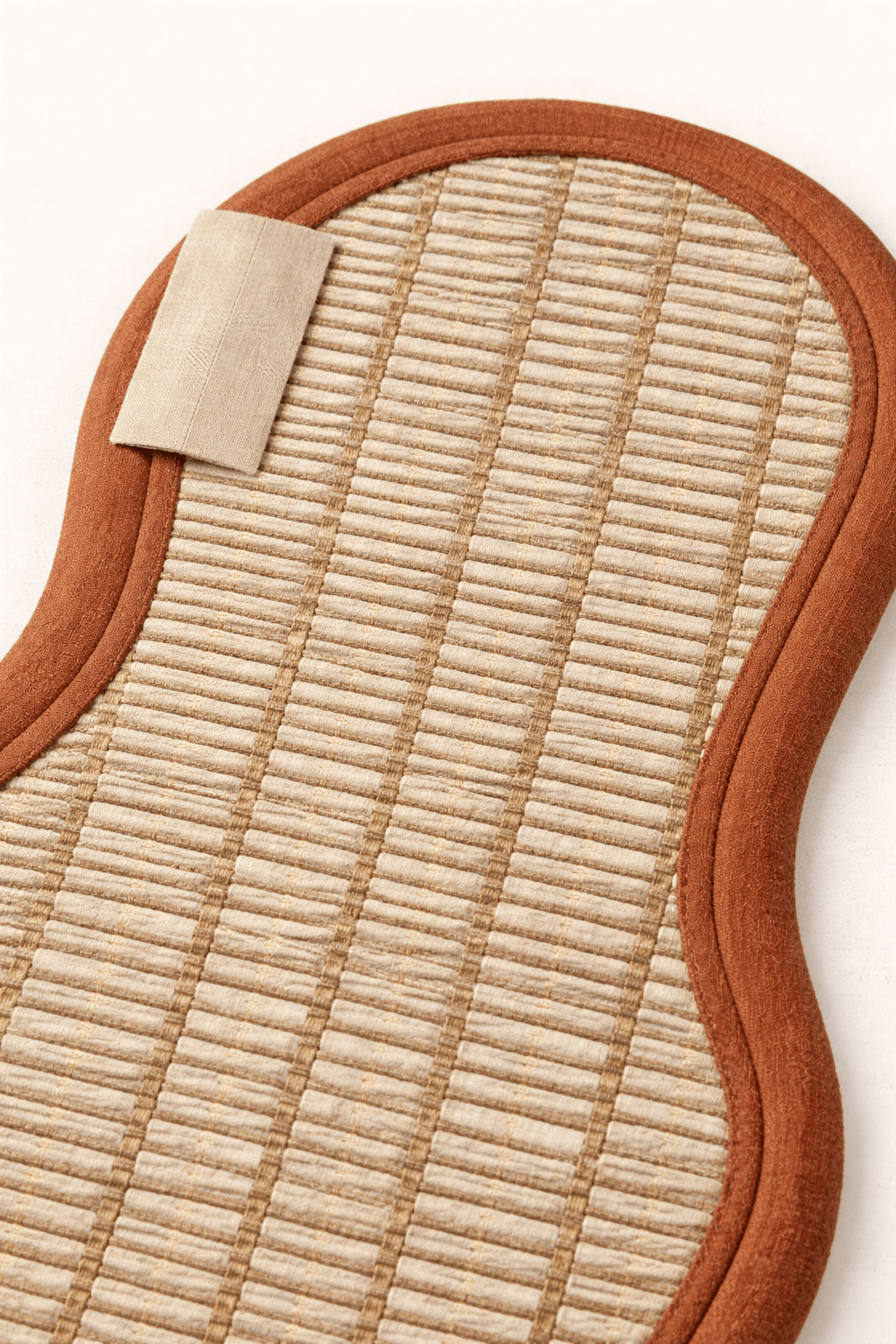 Detail view of the organic geometric area rug with textured design and orange trim.
